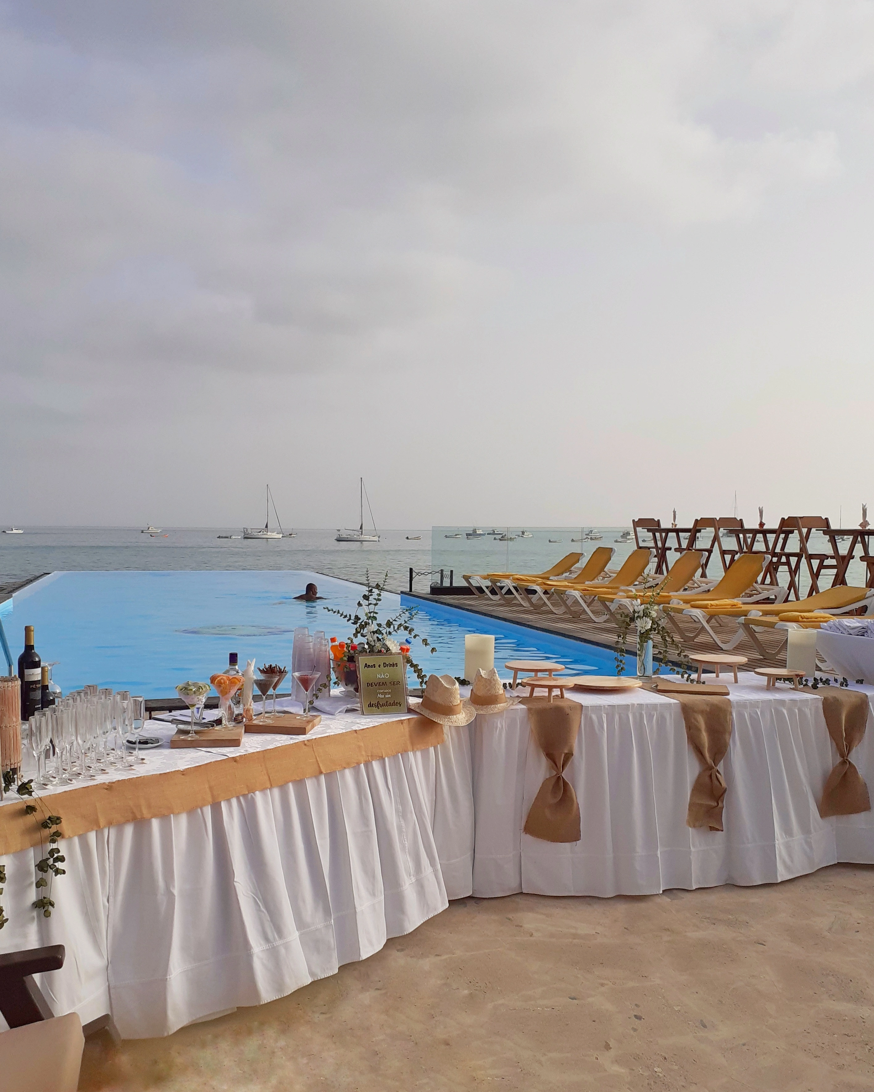 Estação de bebidas montada ao lado da piscina com vista para o mar e placa comemorativa de aniversário. Santa Maria, Ilha do Sal, Cabo Verde.