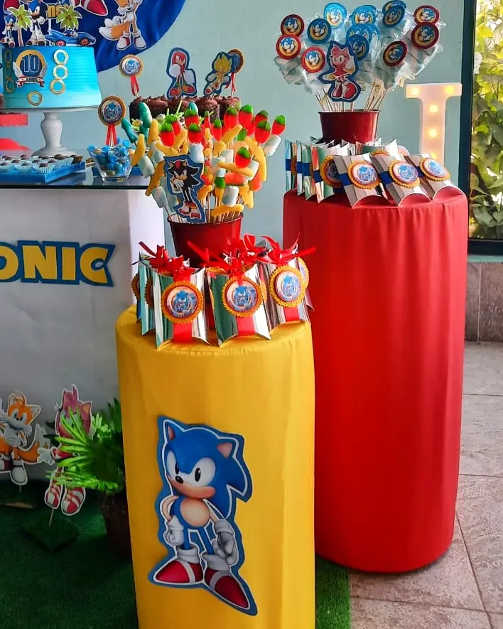 Decoração de festa do Sonic the Hedgehog com mesas cilíndricas amarela e vermelha, doces personalizados e letreiro luminoso do número 10. Espargos, Ilha do Sal, Cabo Verde.