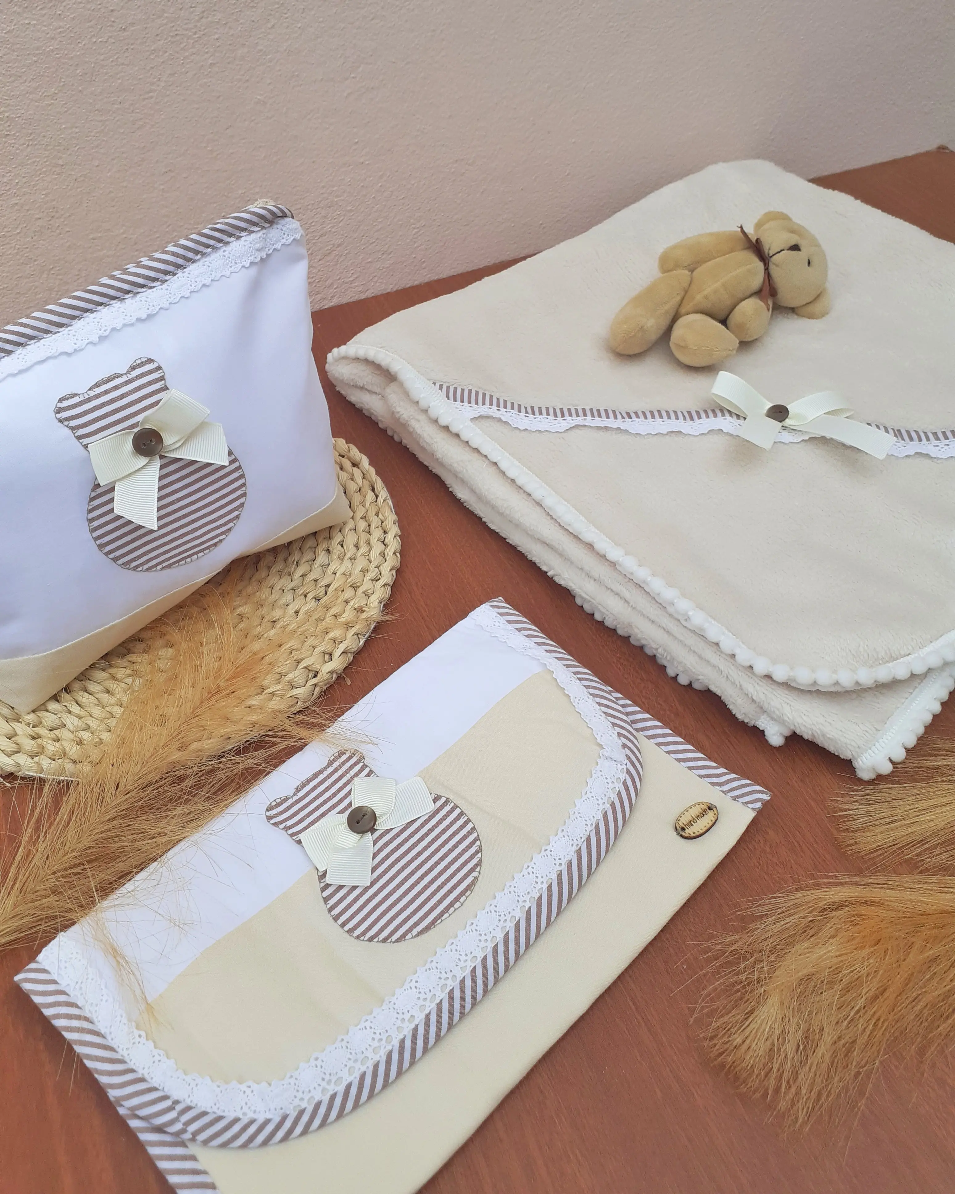 Conjunto de acessórios para bebé com motivo de urso, incluindo bolsa, manta com laço e ursinho de peluche. Ilha do Sal, Cabo Verde.