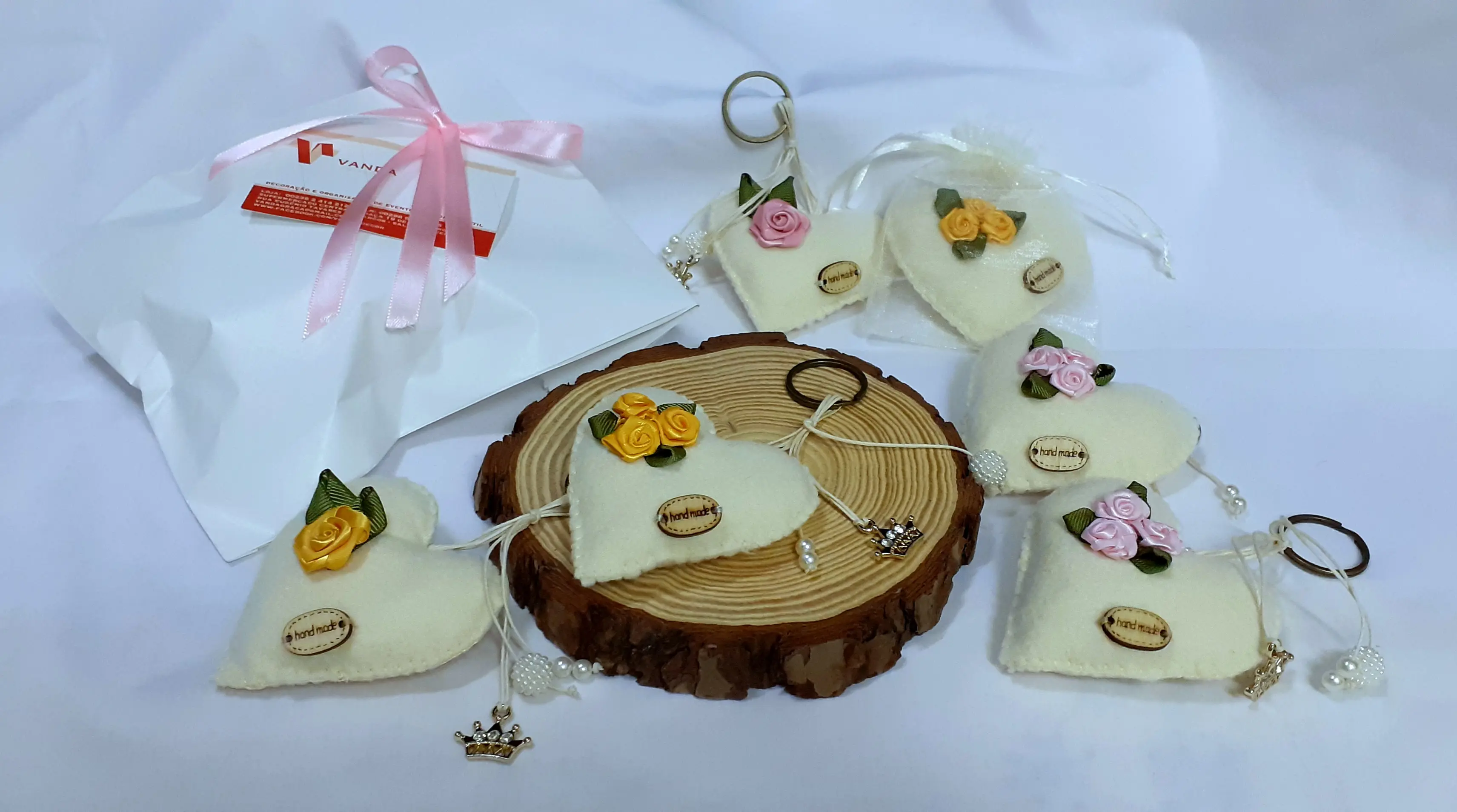 Porta-chaves de feltro em formato de coração branco com pequenas rosas de fita, embalados para presente. Ilha do Sal, Cabo Verde.