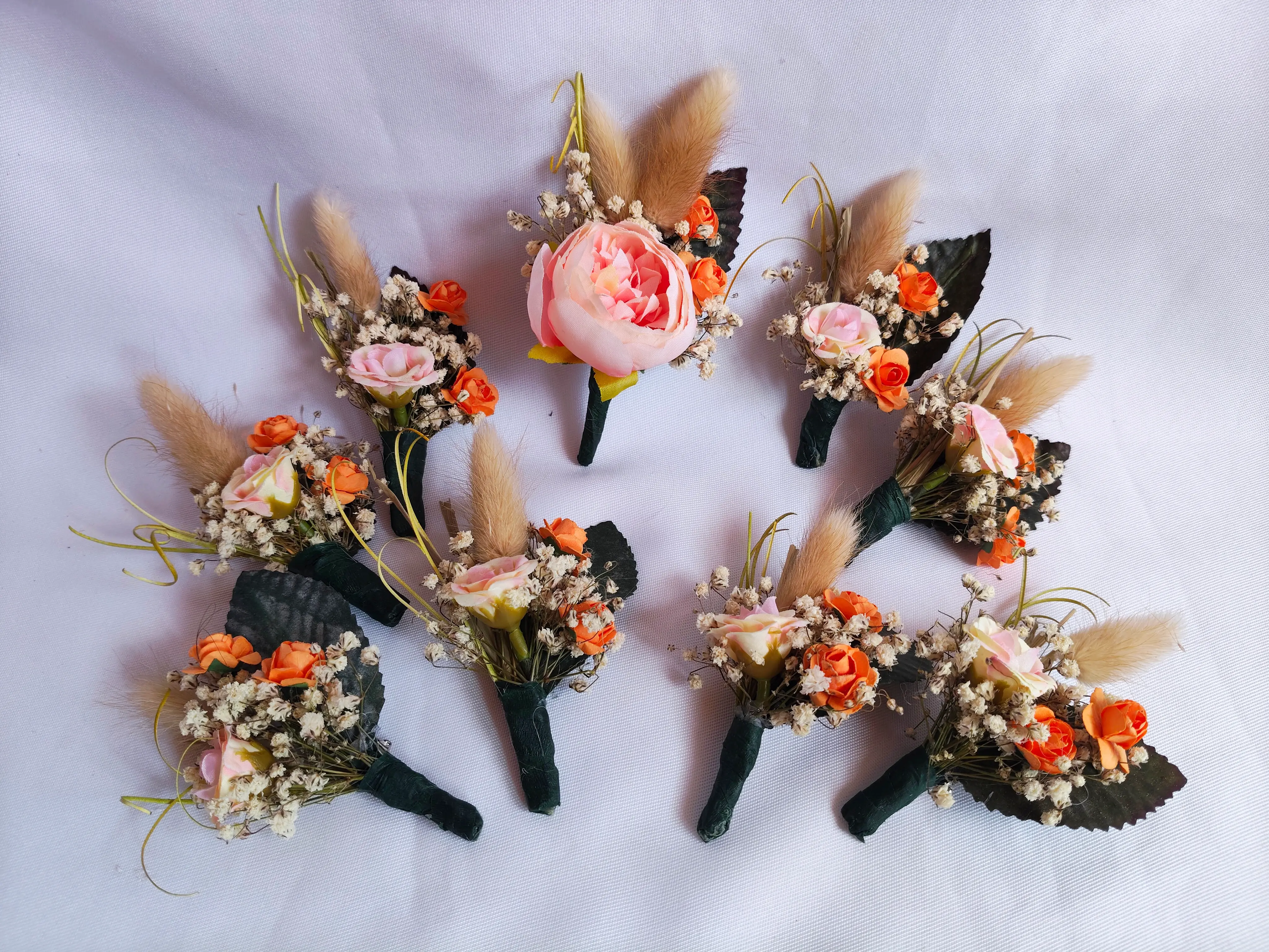 Conjunto de lapelas florais para casamento com rosas em tons de rosa e laranja. Ilha do Sal, Cabo Verde.