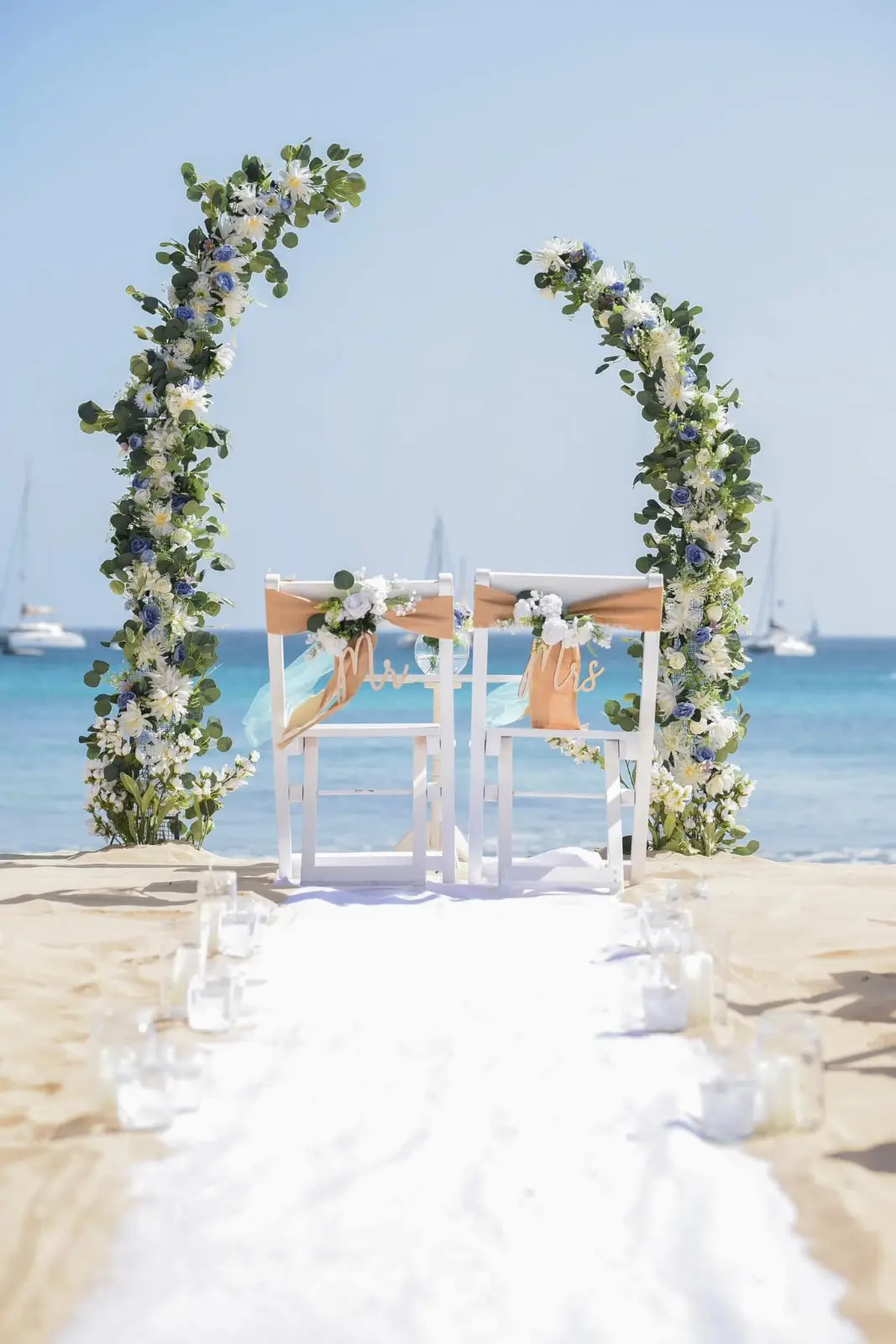 Decoração de altar de casamento na praia com arco floral e cadeiras Mr & Mrs em Santa Maria, Ilha do Sal, Cabo Verde.