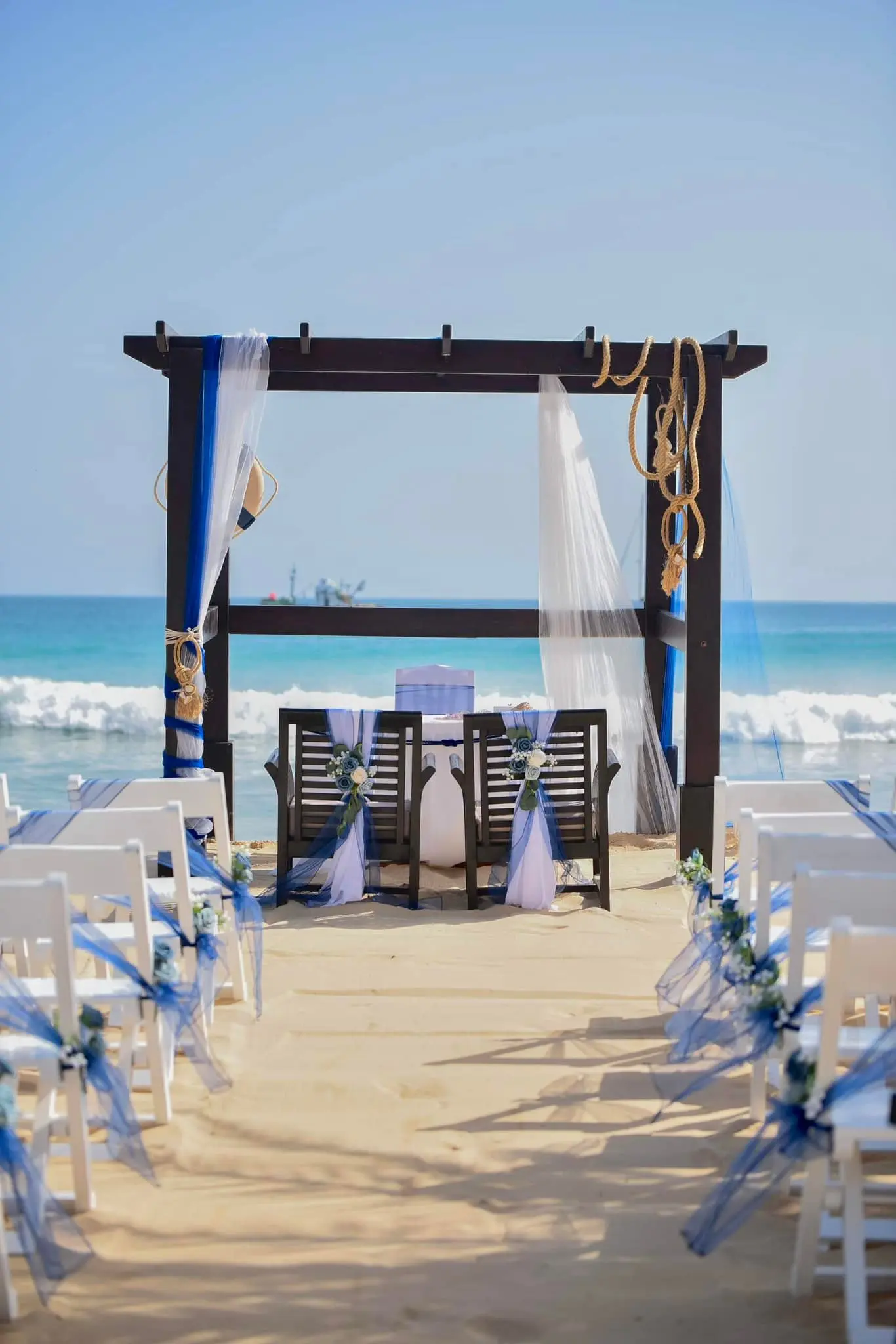 Cenário de casamento náutico com pérgola decorada em azul e branco em Santa Maria, Ilha do Sal, Cabo Verde.