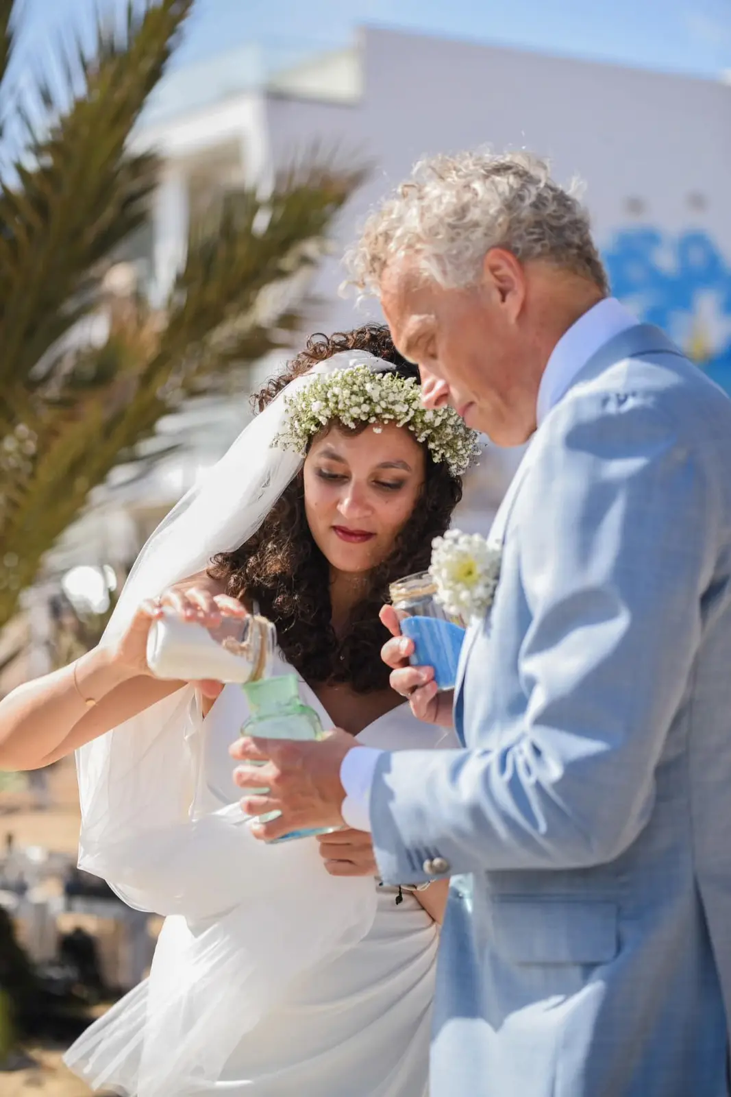 Noivos a realizar a cerimónia das areias durante um casamento simbólico na praia. Ilha do Sal, Cabo Verde.