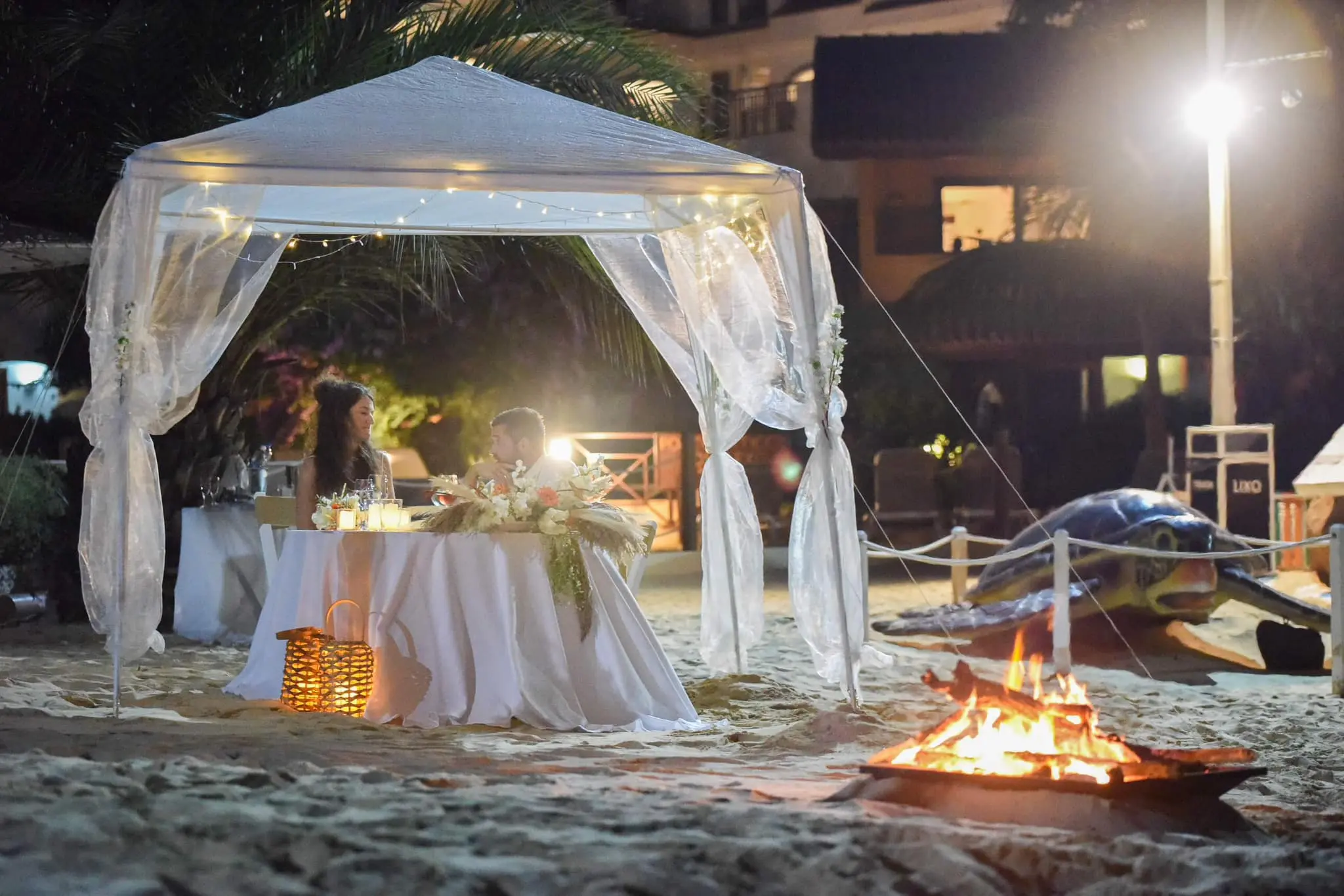 Tenda para jantar romântico decorada na praia com fogueira e vista para o mar em Santa Maria, Ilha do Sal, Cabo Verde.
