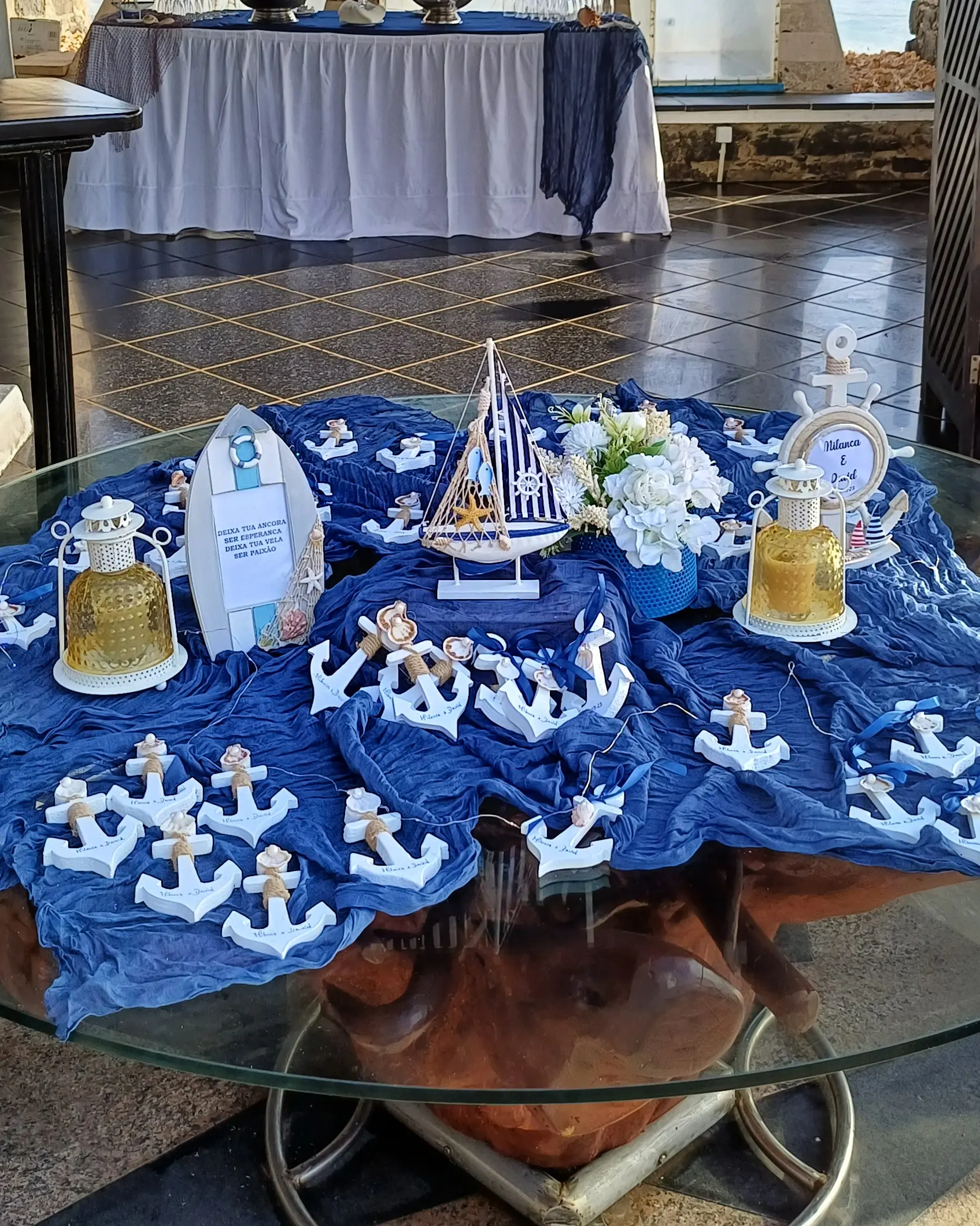 Mesa de lembranças de casamento com tema marítimo, âncoras e barco decorativo em azul e branco. Ilha do Sal, Cabo Verde.